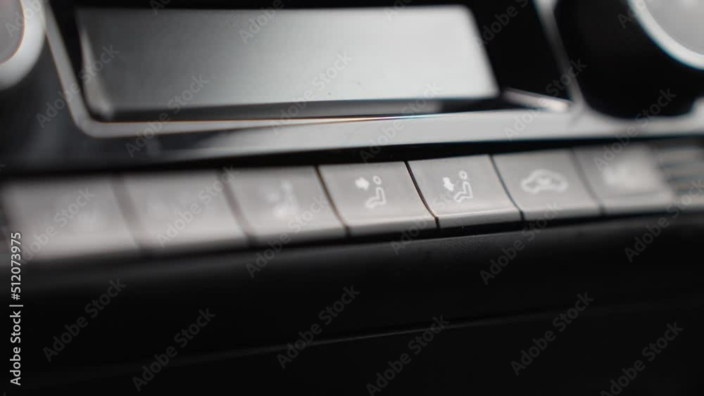 Close up to finger press a button on the car's dashboard to adjust a seat. Close up to finger press a button on the car's dashboard to adjust a seat.
