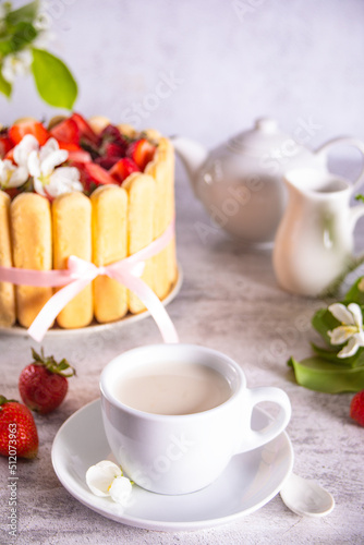 cup of milk teal, cake with fresh strawberries with flowers branch of apple tree