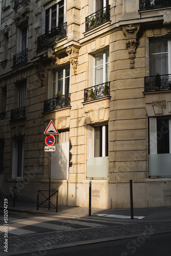 Photography no parking sign near ancient french building with balconies.