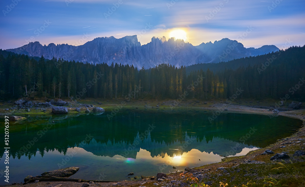 The Karersee lake or Lago di Carezza with reflection of mountains at night in the Dolomites, Italy.