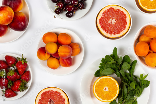 Fototapeta Naklejka Na Ścianę i Meble -  Fresh fruits on white plates, bright summer background