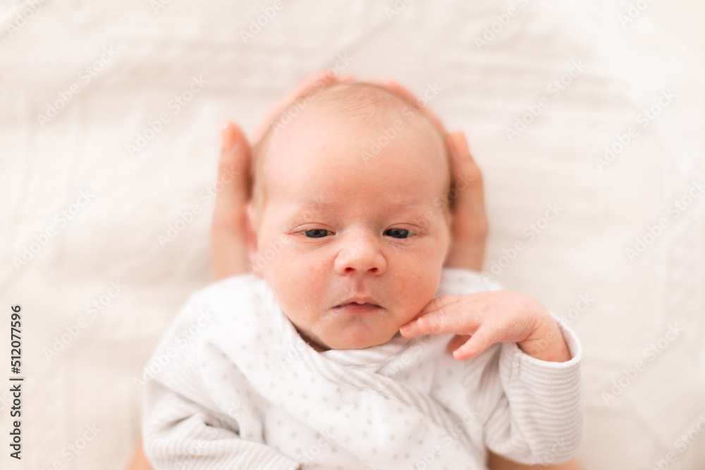 Unrecognizable mother holding her newborn son at home, close-up Unrecognizable mother holding her newborn son at home, close-up