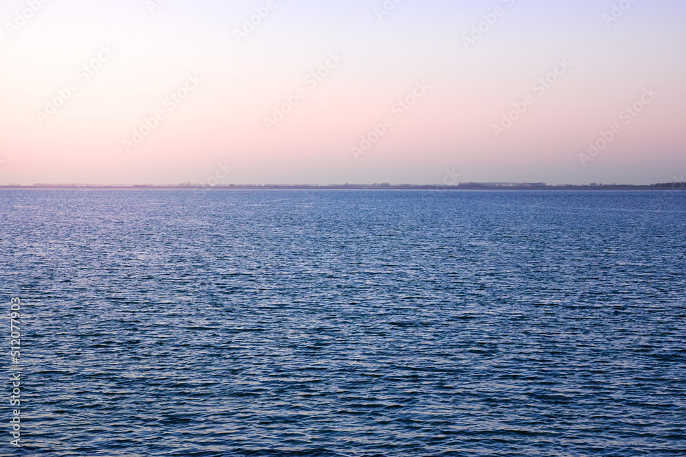 Wide horizon of sea and sky. Sunset seascape. Calm open sea ocean. Sunset evening