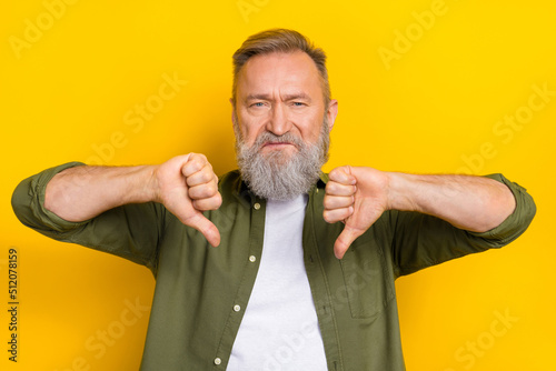 Portrait of unsatisfied person two hands fingers demonstrate thumb down isolated on yellow color background
