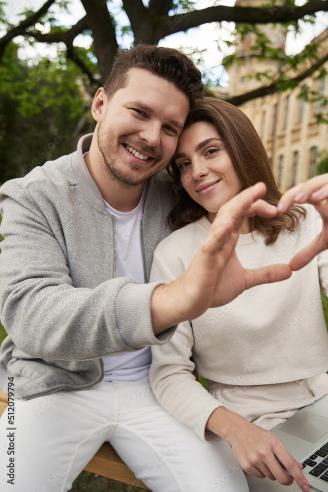 Happy couple making heart symbol with hands on the street Happy couple making heart symbol with hands on the street