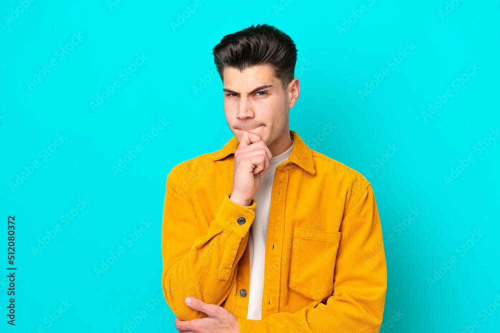 Young handsome caucasian man isolated on blue bakcground having doubts and thinking Young handsome caucasian man isolated on blue bakcground having doubts and thinking