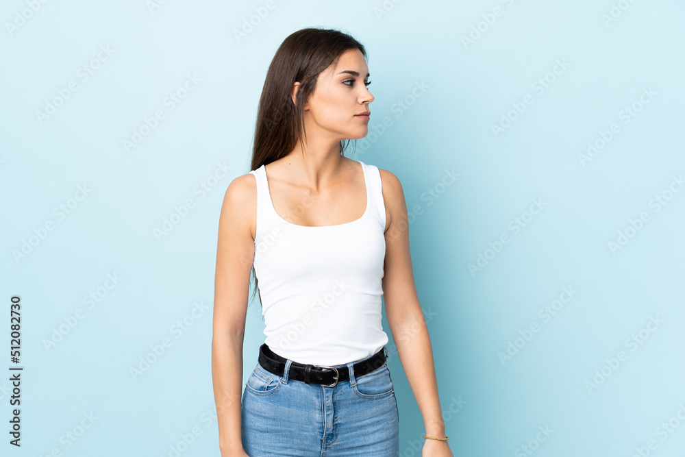 Young caucasian woman isolated on blue background looking to the side Young caucasian woman isolated on blue background looking to the side