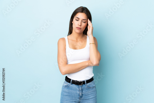 Young caucasian woman isolated on blue background with headache © luismolinero