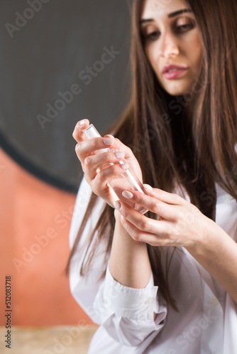 Beauty portrait. A beautiful brunette holds a spray with tonic or micellar water in her hands.