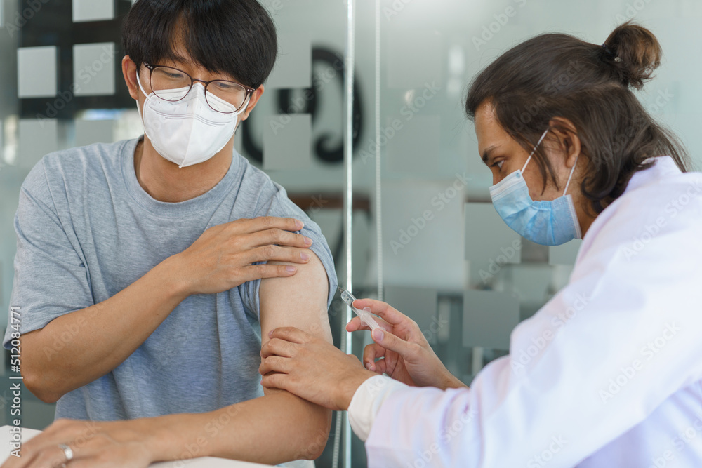 Vaccination concept, Male doctor in face mask injecting vaccine against covid-19 for male patient - obrazy, fototapety, plakaty 