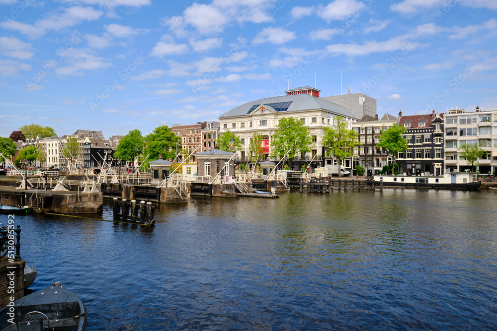 Amsterdam, Netherlands, 11 May 2022 - Panoramic.View of the Amstel river and the city skyline. Blue skies in spring sunshine.