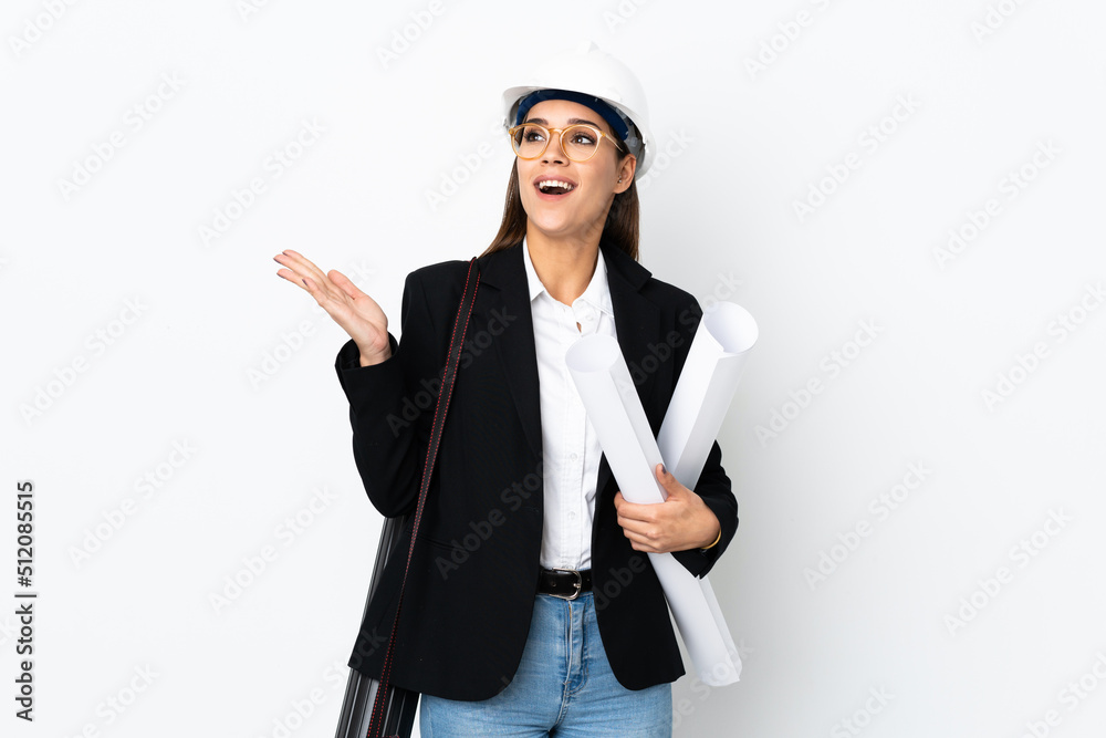 Young architect caucasian woman with helmet and holding blueprints over isolated background with surprise facial expression Young architect caucasian woman with helmet and holding blueprints over isolated background with surprise facial expression