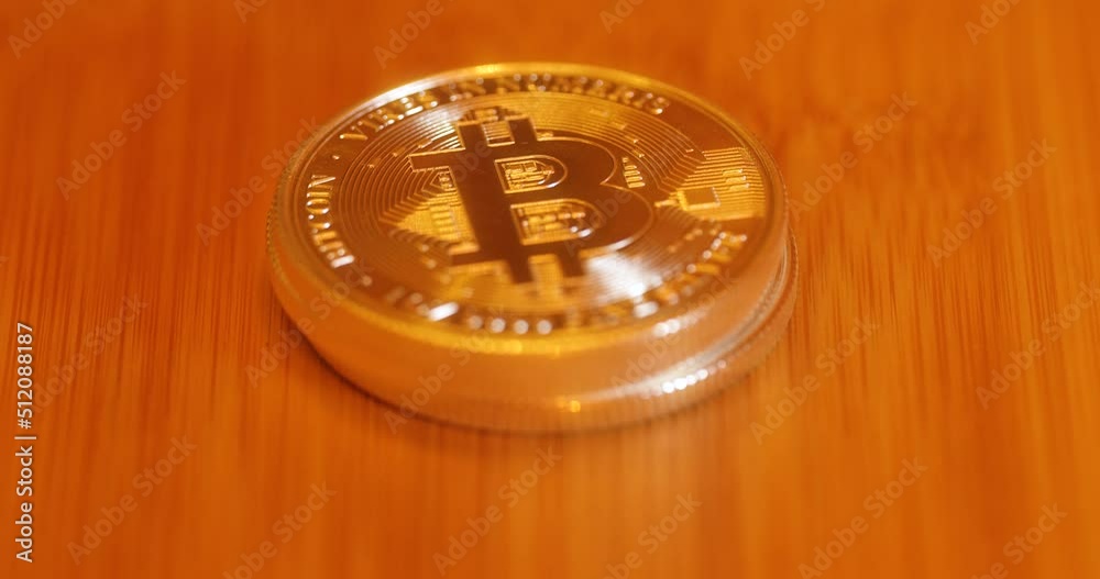 Stop Motion Of Growing Stack Of Gold Bitcoin In The Wooden Table. - close up Stop Motion Of Growing Stack Of Gold Bitcoin In The Wooden Table. - close up