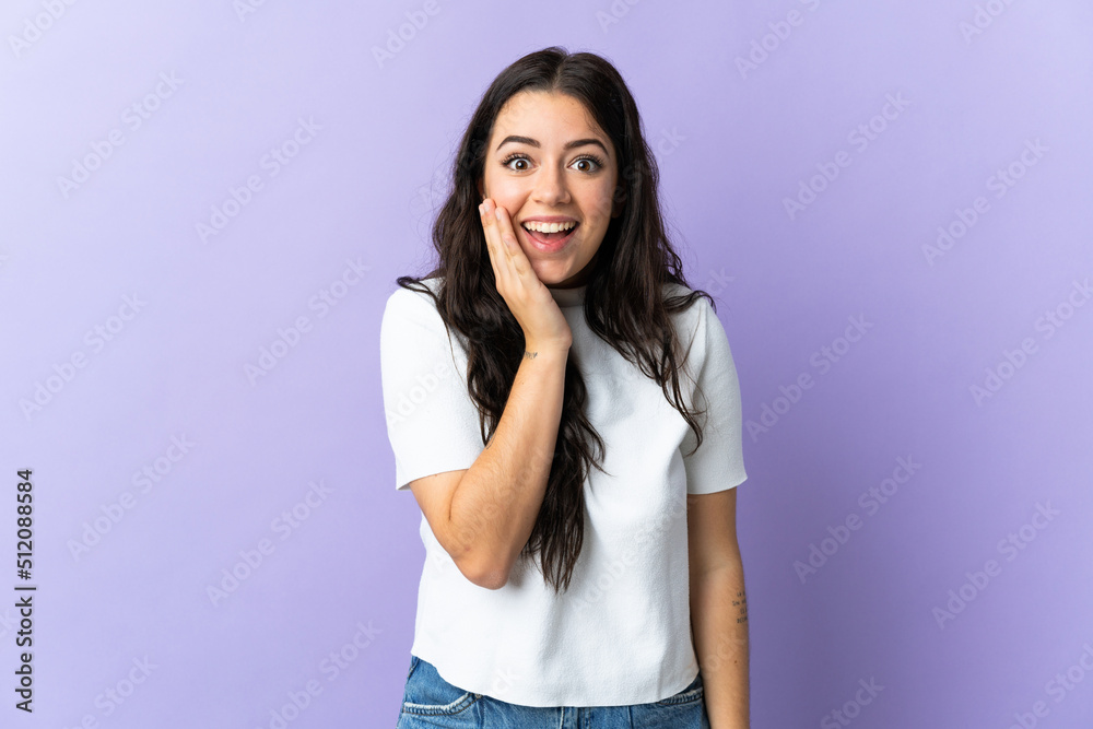 Young caucasian woman isolated on purple background with surprise and shocked facial expression Young caucasian woman isolated on purple background with surprise and shocked facial expression