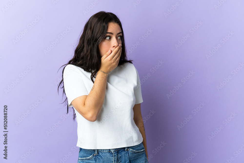 Young caucasian woman isolated on purple background doing surprise gesture while looking to the side Young caucasian woman isolated on purple background doing surprise gesture while looking to the side