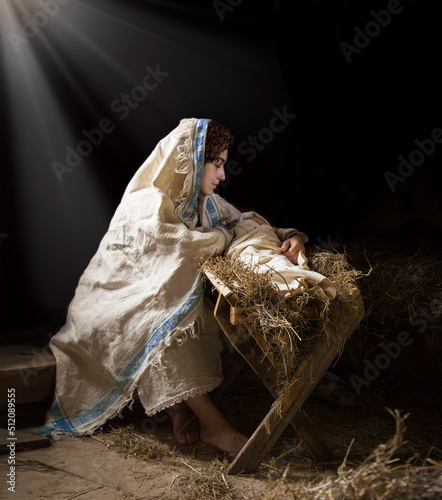 Fotografie Mary sits in the stable near the manger with the baby