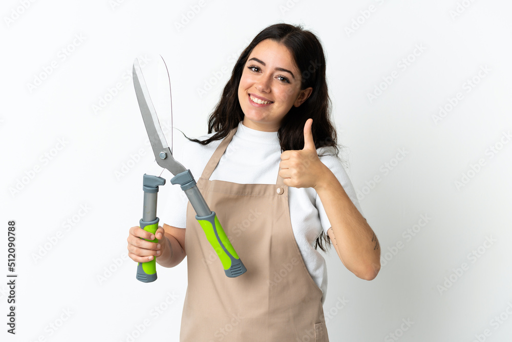 Young caucasian woman holding a plant isolated on white background giving a thumbs up gesture Young caucasian woman holding a plant isolated on white background giving a thumbs up gesture