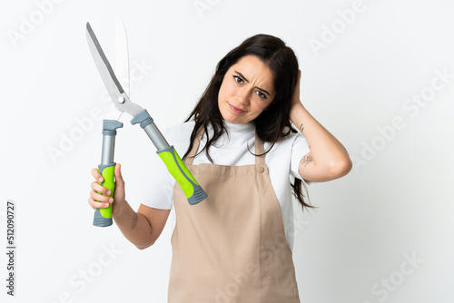 Young caucasian woman holding a plant isolated on white background having doubts