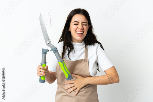 Young caucasian woman holding a plant isolated on white background smiling a lot
