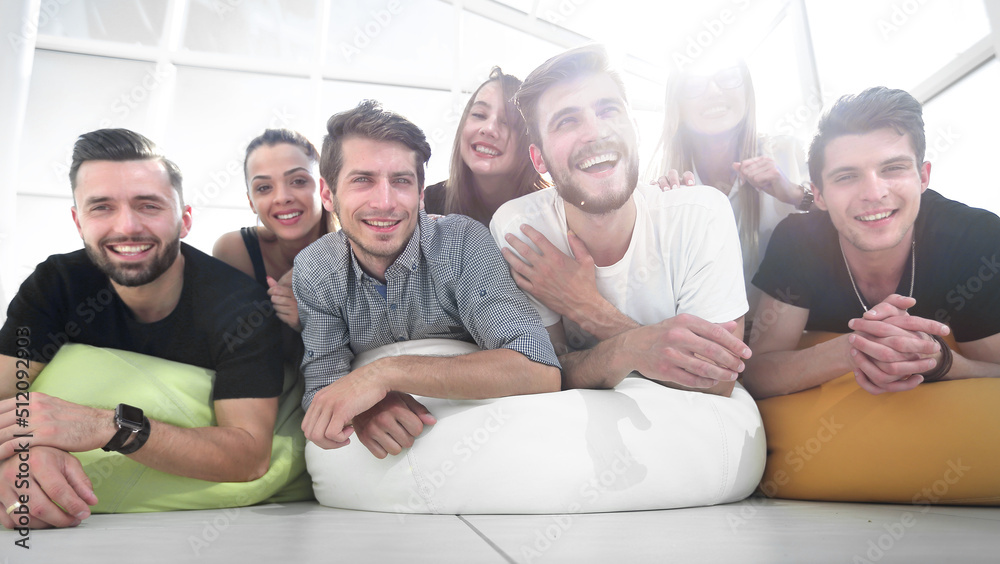 group of young people lying on the floor and smiling group of young people lying on the floor and smiling