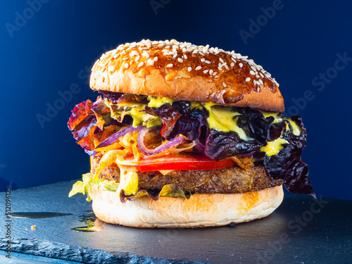 Vegan burger consisting on a slate plate. blue background. Horizontal