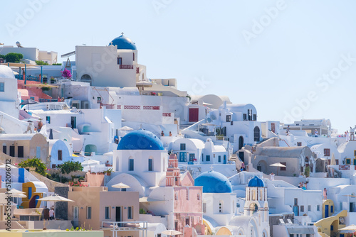 Oia village, Santorini, Greece. Architectural background. View of traditional houses in Santorini. Small narrow streets and rooftops of houses and hotels. Travel and vacation photography.