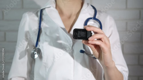Portable oximeter in therapist hands. A doctor hold in her hands a portable oximeter. photo