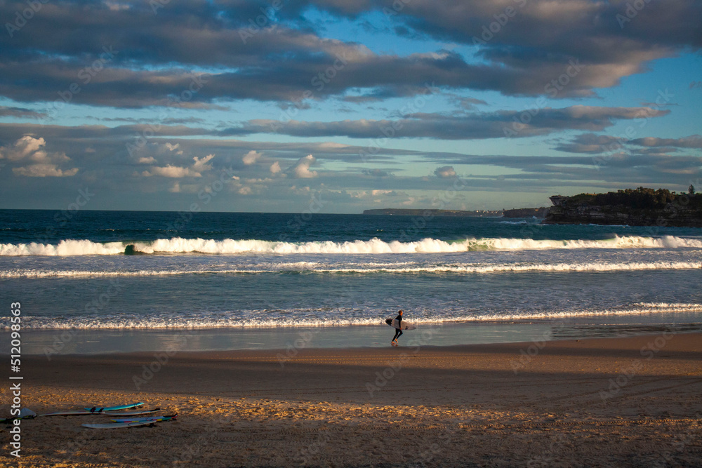 an Australian surfer is walking on the Bondi Beach, Sydney with his surfboard