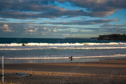 an Australian surfer is walking on the Bondi Beach, Sydney with his surfboard