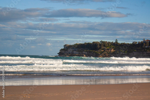 as the waves crash on the shore Bondi Beach, Sydney, with a hills