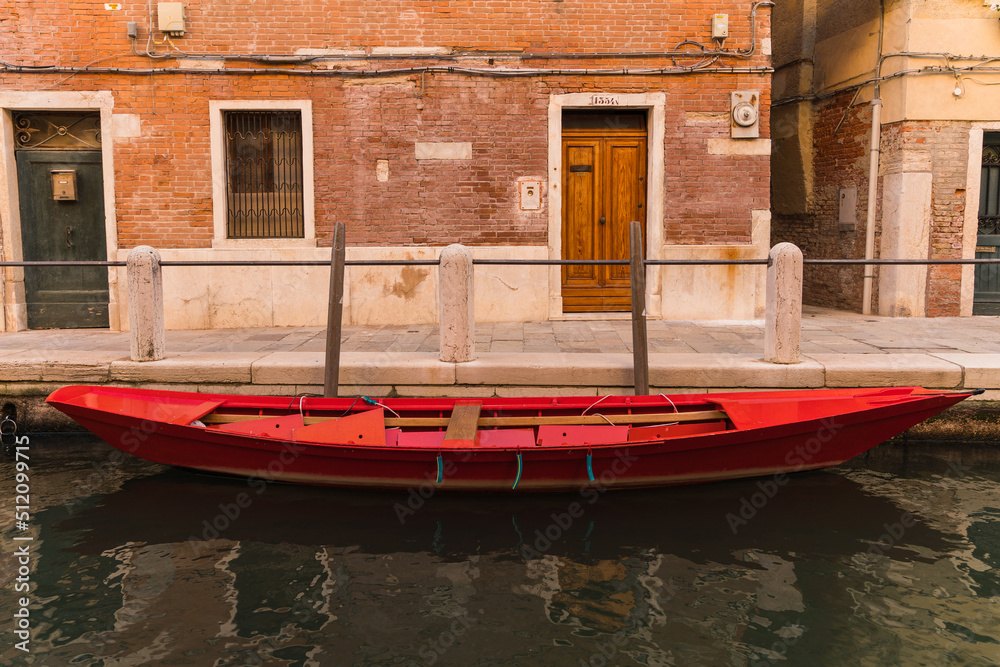 old red wooden boat docked by canal and building in venice, italy old red wooden boat docked by canal and building in venice, italy
