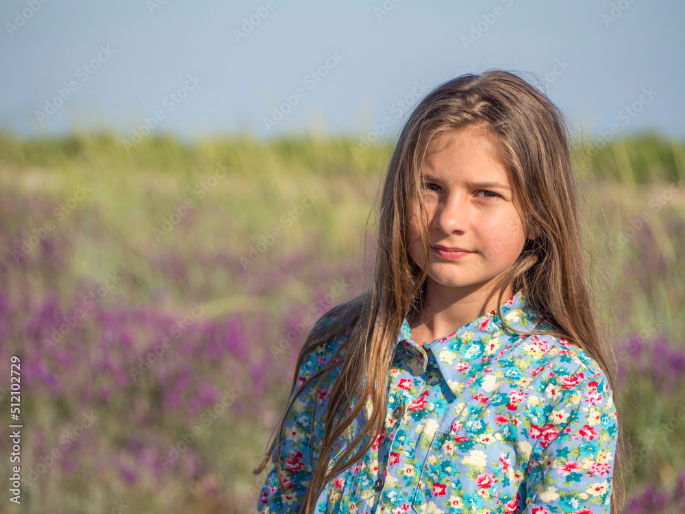 Portrait of a beautiful girl in an amazing blooming field. Nature, recreation and lifestyle. Teenage girl in a dress enjoying nature Portrait of a beautiful girl in an amazing blooming field. Nature, recreation and lifestyle. Teenage girl in a dress enjoying nature