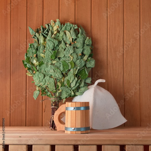 Birch broom, mug and hat on the shelf in the bath. Health and Clean Concept