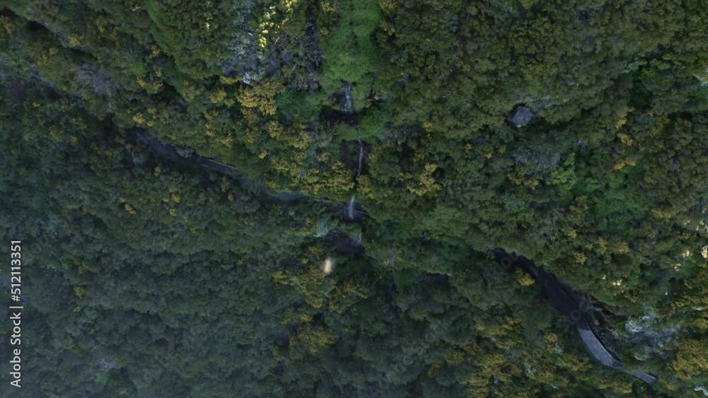 Aerial topdown view of a narrow waterfall along a green cliff in Madeira Aerial topdown view of a narrow waterfall along a green cliff in Madeira