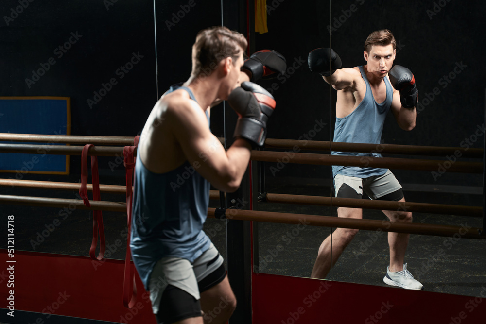 Professional sportsman in boxing gloves practicing jabs - obrazy, fototapety, plakaty 