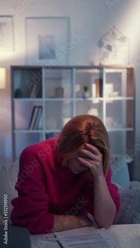 Facepalm gesture. Displeased woman. Clueless task. Embarrassed lady covering face with hand feeling epic fail sitting desk light room interior looped vertical.