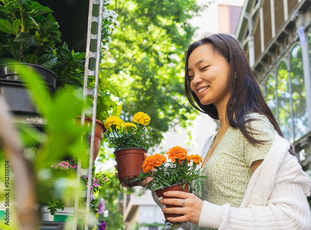 Content Asian woman with potted flowers in floral market Content Asian woman with potted flowers in floral market