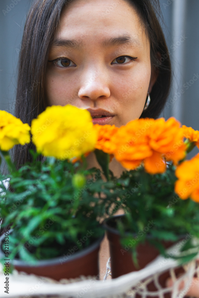 Asian woman with marigold flowers in pots Asian woman with marigold flowers in pots
