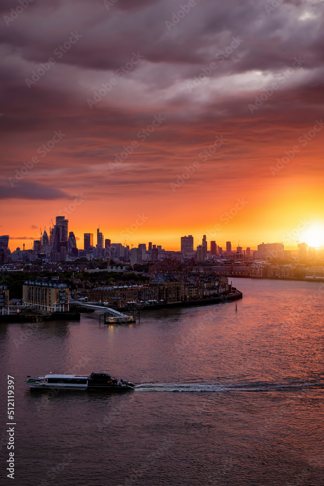 A spectacular sunset behind the modern skyline of London and river Thames during summer time, England