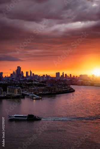 A spectacular sunset behind the modern skyline of London and river Thames during summer time, England