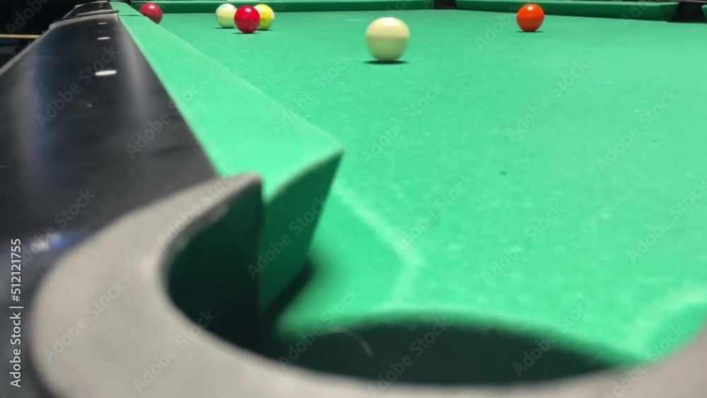 pool game, a player on a billiard table pockets a ball