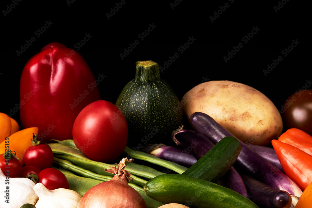Variety of juicy vegetables on a black background. Healthy food