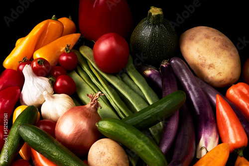 Variety of juicy vegetables on a black background. Vegetarian food