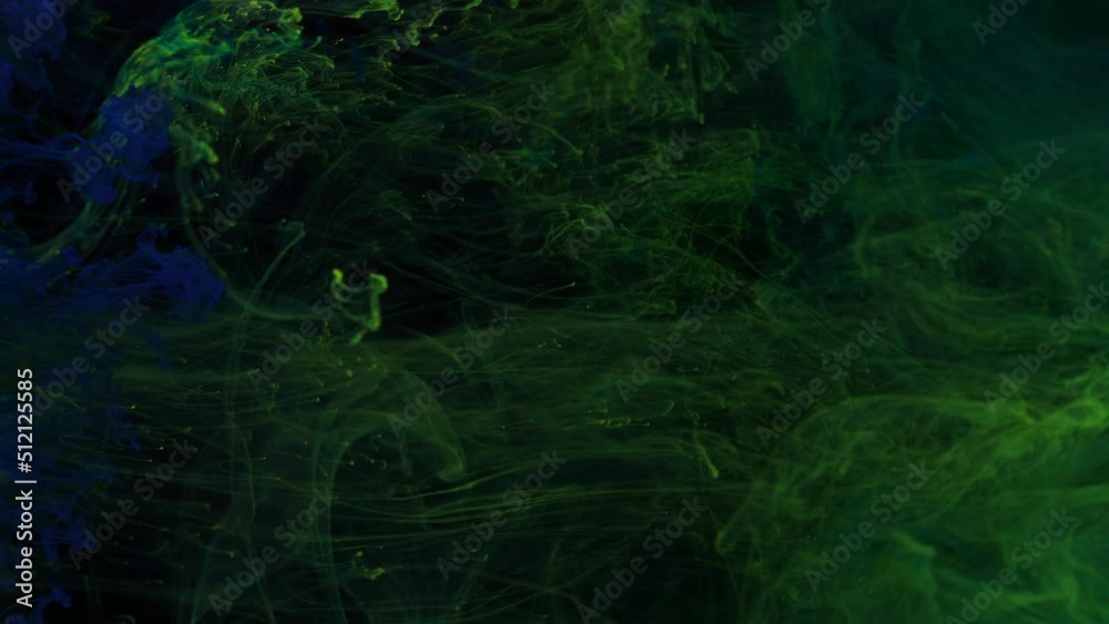 Stream of blue and yellow, green paint dissolves in a transparent space on a black background. Stream of blue and yellow, green paint dissolves in a transparent space on a black background.