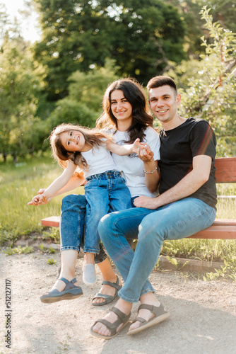 Family with daughter sitting on a bench