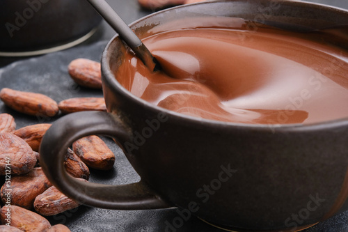 Hot liquid chocolate in a cup with a cocoa beans. Cup of molten hot chocolate. Menu, confectionery, recipe concept. Shallow depth of field