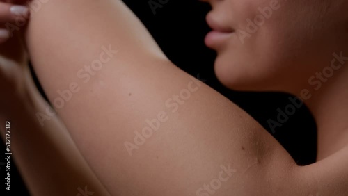 Wallpaper Mural Big close-up shot of good-looking young slim white-skinned woman strokes her smooth arm on black background | Soft skin concept Torontodigital.ca