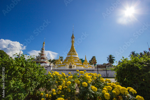 Wat Chong Klang,Mae Hong Son,northern Thailand on November 19,2017:Burmese-style white and golden chedi and 5-tier pyatthat with blue sky background photo