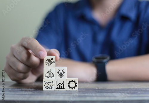 business man hand arranging wood block stacking with business strategy and Action plan,targeting the business concept.business development concept.