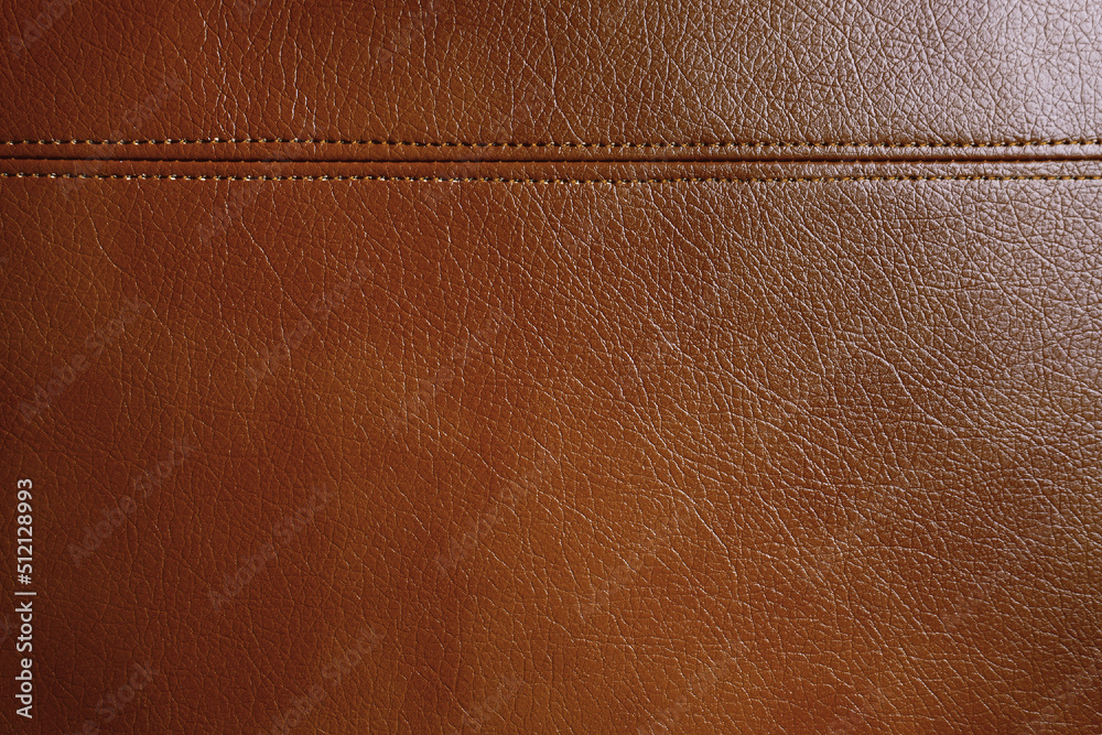 Fototapeta premium Natural, artificial brown leather texture background with decorative seam. Material for sport items, clothes, furnitre and interior design. ecological friendly leatherette.